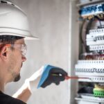 man-an-electrical-technician-working-in-a-switchboard-with-fuses-installation-and-connection-of-electrical-equipment+(1)